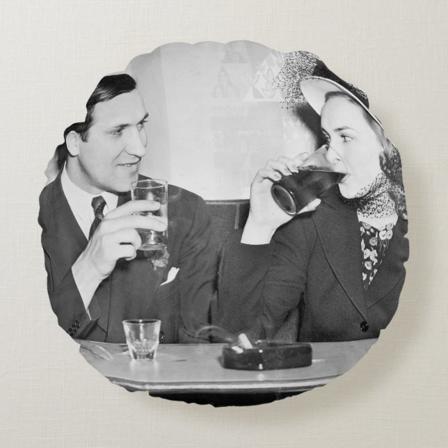 Couple sitting together in a restaurant flirting w round cushion (Front)