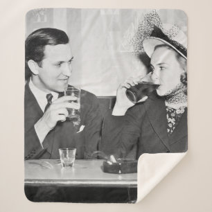 Couple sitting together in a restaurant flirting w sherpa blanket