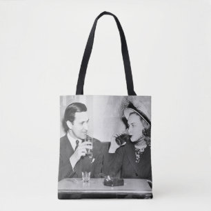 Couple sitting together in a restaurant flirting w tote bag