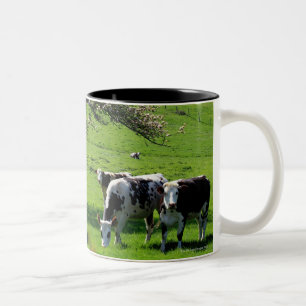 Cow among blooming apple trees in Normandy Two-Tone Coffee Mug