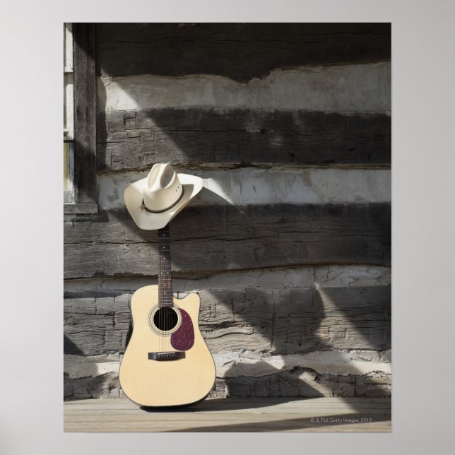 Cowboy hat on guitar leaning on log cabin poster (Front)