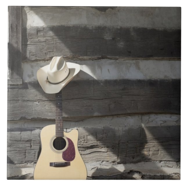 Cowboy hat on guitar leaning on log cabin tile (Front)