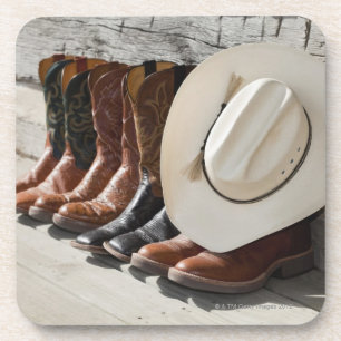 Cowboy hat on row of cowboy boots outside a log coaster