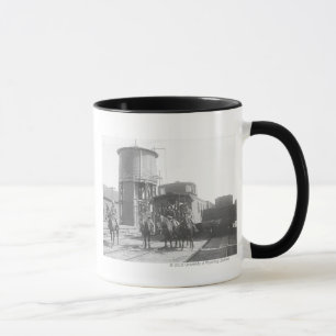 Cowboys on horses posing in front of a train mug