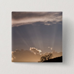 Crepuscular rays radiate across the sky at 15 cm square badge
