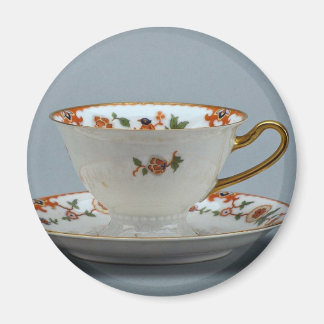 Cup and saucer with colourful flowers on it. magnet