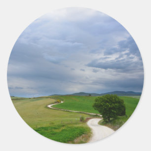 Curvy road towards a destination round sticker