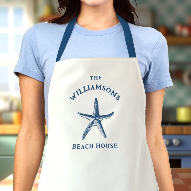 Custom Blue Coastal Starfish Beach House Apron (Woman in a kitchen wearing a white apron with a blue starfish design and The Williamsons Beach House)