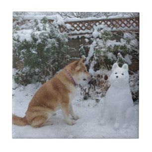 cute akita sitting with snowman in the snow dog tile