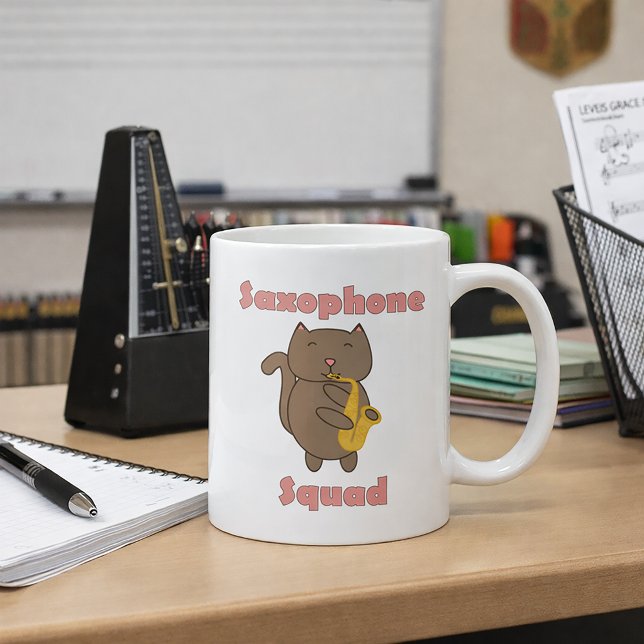 Cute Cat Playing Saxophone “Saxophone Squad” Music Coffee Mug (A mug with a cute cat playing the saxophone and the words saxophone squad in pink.)