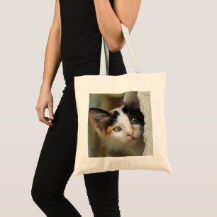 Cute curious kitten with prying eyes tote bag