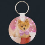 Cute Dog with Pink Bow Christmas Photograph Key Ring<br><div class="desc">A keychain with an adorable Christmas dog wearing a cute pink plaid bow tie. This tiny little pet is sitting inside a whimsical hat box. A white tree decorated with pink lights in the background. The lights are blurred giving it a magical bokeh effect. Darling Christmas themed photograph. Perfect for...</div>