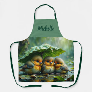 Cute fluffy birds hiding under leaf in rain apron