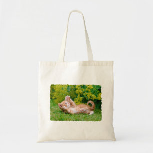 Cute funny cat kitten playing in a flowery garden tote bag