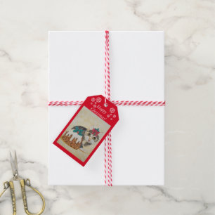 cute grey tabby kitten licking paw at christmas  gift tags