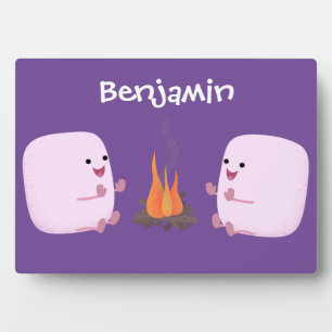 Cute pink marshmallows by camp fire cartoon plaque