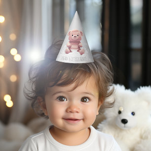 cute teddy bear on pile of diapers 1st birthday party hat