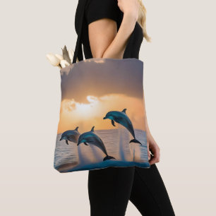 Dancing in the Dusk: Three Dolphins Leaping Tote Bag