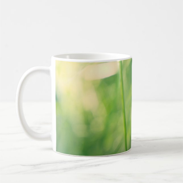 Dandelion in greenery with soft summer light coffee mug (Left)