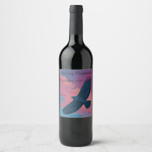 Dark hawk with wings spread across a sunset pink s wine label