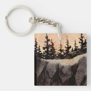 Dark pines on sheer cliff with greyed pink sky art key ring