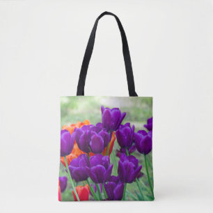 Dark purple tulips on a sunny day in the garden tote bag