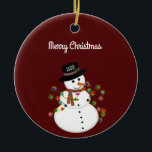 Dated Merry Christmas Snowman Personalised Ceramic Tree Decoration<br><div class="desc">Cute snowman is tangled with lit Christmas lights, has the year on his hat - The "Merry Christmas" text above can be changed or added to, and the font style/size can also be changed. Shown on a deep red background, which can be changed to any colour you prefer. The ornament...</div>