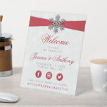 Diamante Snowflake & Red Ribbon Winter Wedding Pedestal Sign<br><div class="desc">The diamanté snowflake & red ribbon wedding collection is perfect for any couple planning a romantic winter wedding celebration. The design features a light silvery grey and white snowflake textured background with a diamanté snowflake on top of a silky looking ribbon. The wording incorporates the same silvery grey and red...</div>