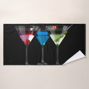 Different cocktails in martini glasses on black bath towel