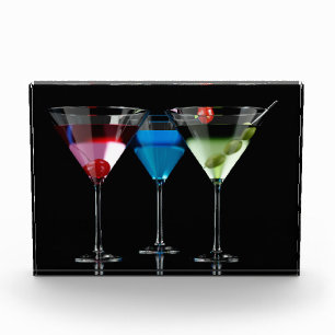 Different cocktails in martini glasses on black photo block