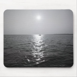 Distant boat on ocean mouse mat