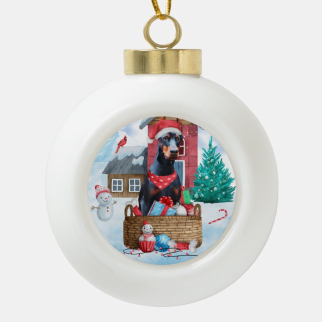 Doberman Dog In snow Christmas Dog House Ceramic Ball Christmas Ornament (Front)