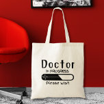 Doctor in Progress Please wait  Tote Bag<br><div class="desc">Step into the realm of medicine with confidence and style with our "Doctor in Progress: Please Wait" tote bag. Crafted with the busy medical student or aspiring physician in mind, this tote bag serves as a practical accessory to carry your essentials while making a statement about your journey in medicine...</div>