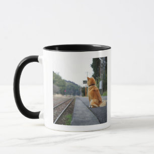 Dog sitting on train station mug