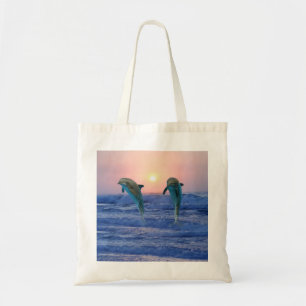 Dolphins at sunrise tote bag
