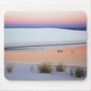 Dusk sky reflected in pool of water from mouse mat