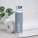 Dusty Blue Personalised Wedding Bridesmaid Water Bottle<br><div class="desc">Gift your wedding bridesmaid or maid of honour with this trendy, vacuum Insulated water bottle that features her name in white, stylised script on a dusty blue colour background designed to match your wedding colour scheme. Personalise bottle by editing and replacing name with your own as desired. Select your water...</div>