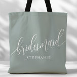 Dusty Sage Bridesmaid Modern Script Tote Bag<br><div class="desc">Show your appreciation to your bridal party with this stylish dusty sage green bridesmaid tote bag. Featuring modern script and customisable with your bridesmaid's name, this tote bag is both practical and elegant. The soft colour and chic design make it perfect for carrying wedding day essentials or everyday items. This...</div>