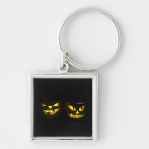 Eerie yellow glow pumpkin faces on black  key ring