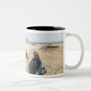 Egypt, Giza. Native man feeds his camel in Two-Tone Coffee Mug