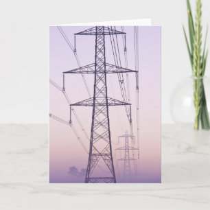 Electricity pylons in mist at dawn. card