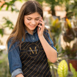 Elegant Black and Gold Striped Monogram Name Apron<br><div class="desc">Add an elegant touch to your kitchen with this stylish apron. The black colour makes it easy to match any décor,  while the metallic gold monogram adds a luxe and modern look. The sleek stripes and gold monogram add a touch of sophistication to your kitchen.</div>