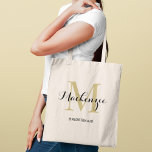Elegant Gold Black Custom Wedding Bridesmaid Name Tote Bag<br><div class="desc">Elegant custom wedding tote bag features a personalised monogram typography design with modern calligraphy script name and serif monogram initial in rich gold and black colours. Includes custom text for a bridal party title like "BRIDESMAID" or other preferred wording.</div>