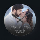 Elegant Wedding Photo Chic NewlyWed Round Clock<br><div class="desc">This elegant script photo clock will be a beautiful keepsake of your wedding day! The unique calligraphy reads 'Mr and Mrs' alongside your custom family name and date. Add your wedding photo and make this into a perfect gift for the newlywed bride,  an anniversary,  or vow renewal!</div>