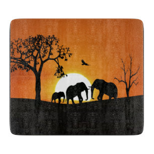 Elephants at sunset cutting board
