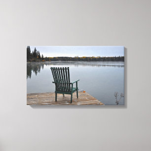 Empty chair on lake deck canvas print