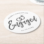 Engagement Party Script Lettering | Round Paper Coaster<br><div class="desc">A fun and unique script lettered paper coaster tailored specifically to you an engagement party.  It features the word "engaged" with wedding rings resting over it. Underneath this and above it are the names of the bride and groom and the engagement date.</div>