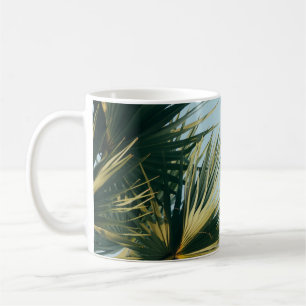 Fan palm tree under blue sky coffee mug