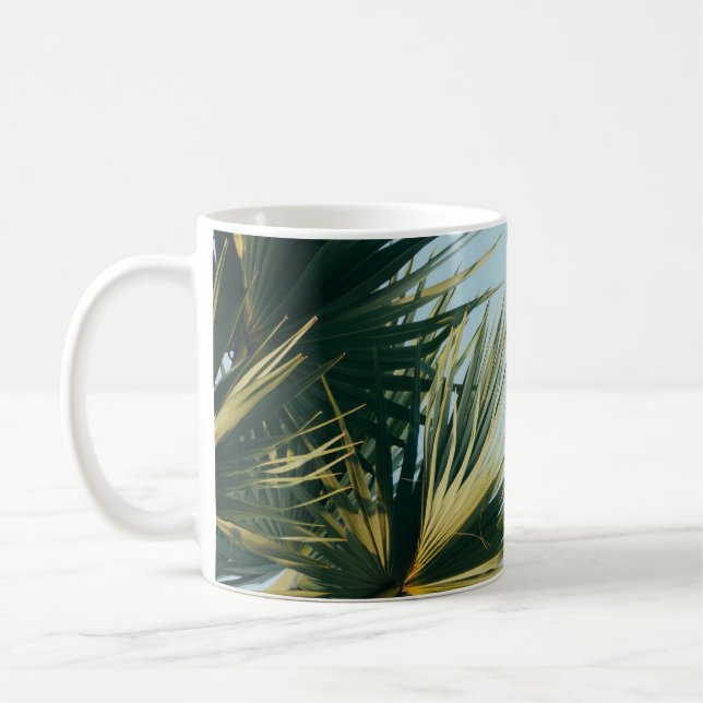 Fan palm tree under blue sky coffee mug (Left)