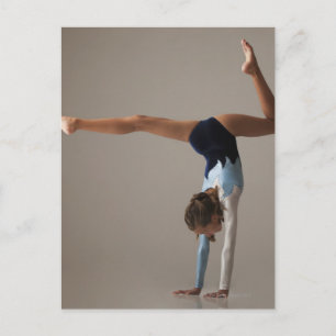 Female gymnast (12-13) performing handstand postcard